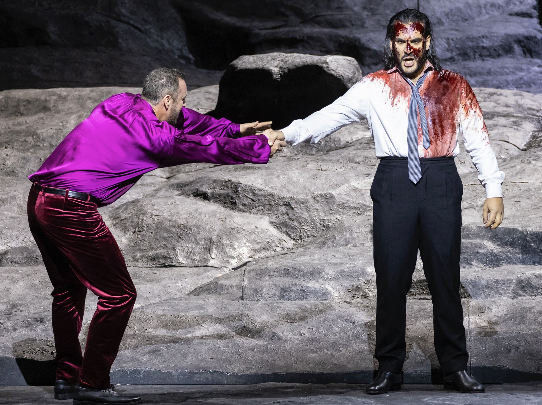 Christian Van Horn in a magenta suit facing another performer in Don Giovanni