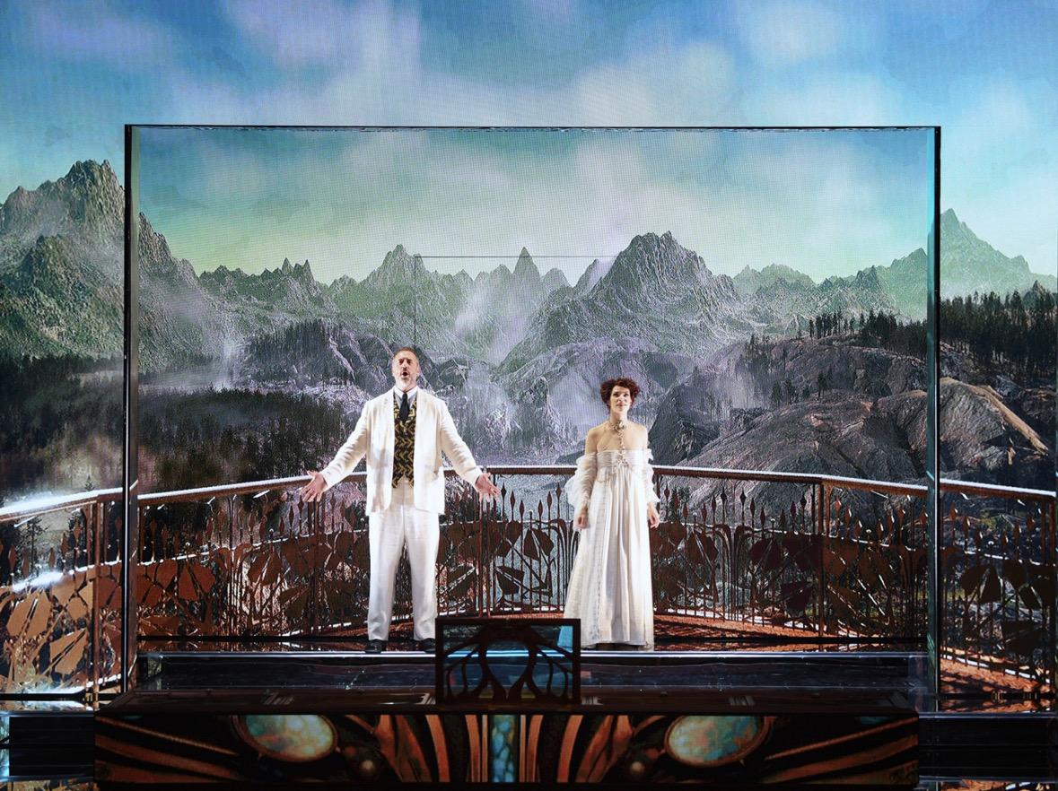 Christian Van Horn and Sara Gartland as Bluebeard and Judith before a projected mountain landscape in Des Moines Metro Opera’s Bluebeard’s Castle.