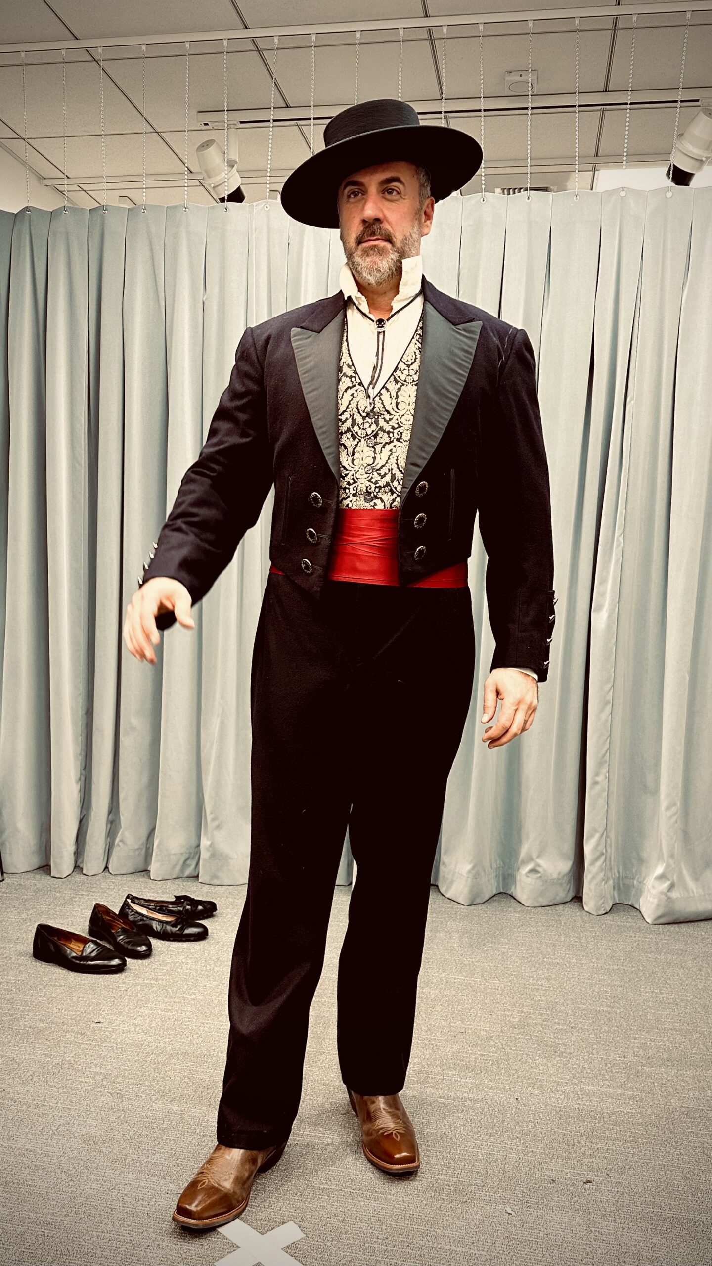 Christian Van Horn in Escamillo costume with hat and red sash, backstage.