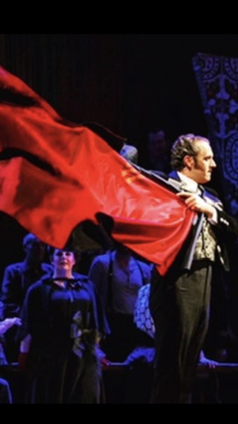 Christian Van Horn as Escamillo swings a red cape onstage.